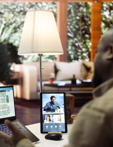 Businessman discussing the annual report with investors via videocall, showcasing financial data and market analysis from his laptop at home. Entrepreneur working to obtain insurance funds.