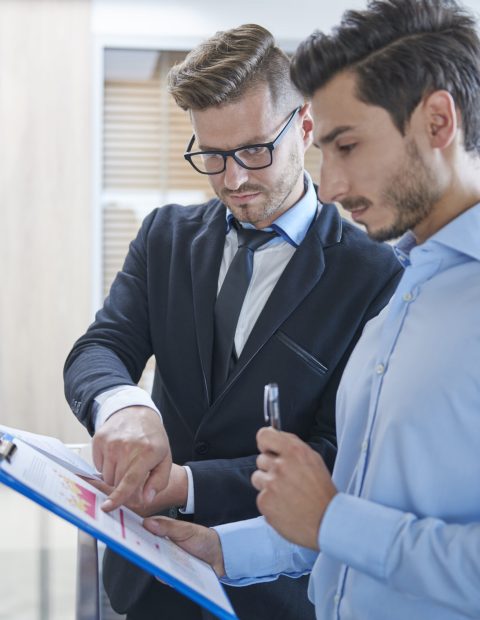 Two men analyzing some documents